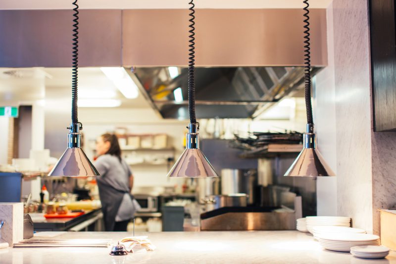 Cucina professionale in acciaio con lampade a sospensione durante il servizio