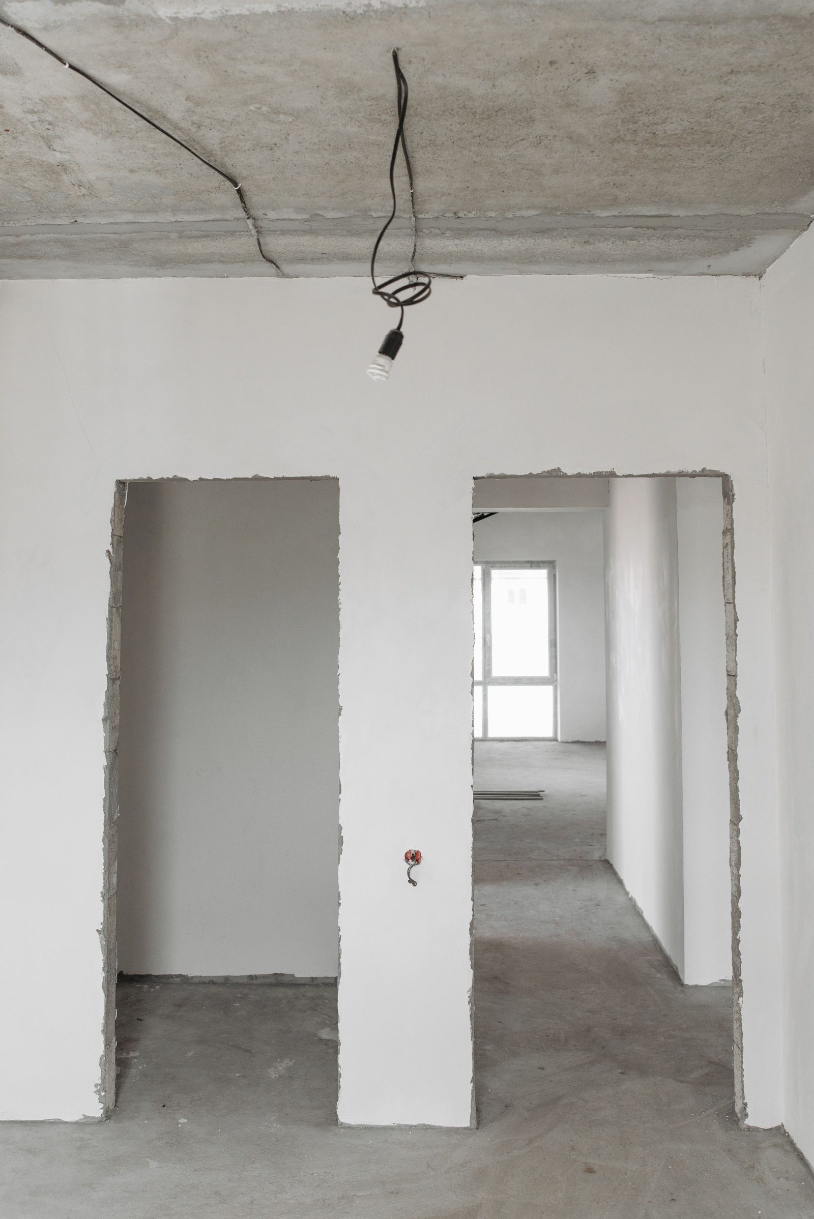Interno di un immobile al grezzo con soffitto in cemento e pareti da rifinire