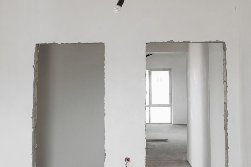 Interno di un immobile al grezzo con soffitto in cemento e pareti da rifinire
