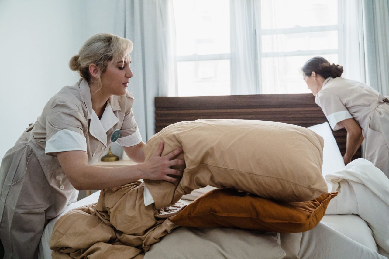Due addette al piano sistemano la biancheria di un letto